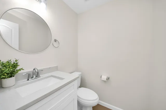 a bathroom with a sink toilet and a mirror