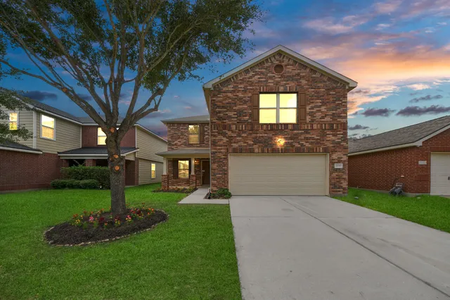 a front view of a house with a yard and garage