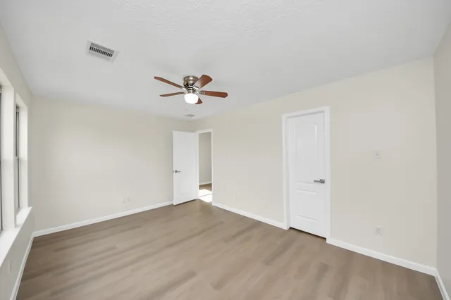 a view of a room with wooden floor and ceiling fan