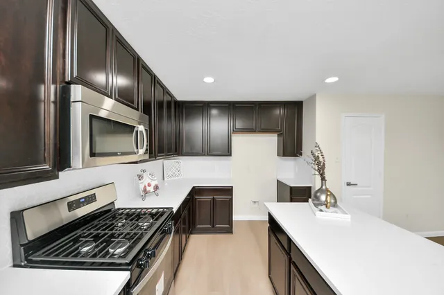 a kitchen with stainless steel appliances a stove sink and microwave