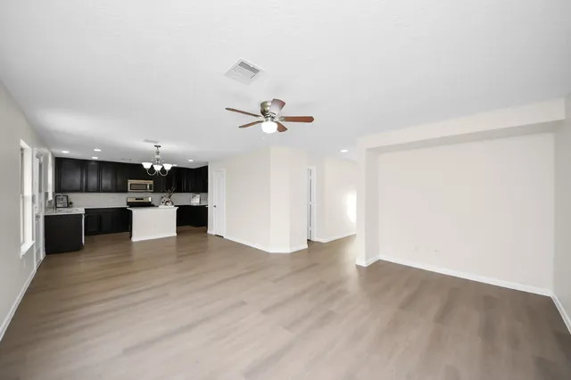 a view of kitchen with kitchen island white cabinets and refrigerator