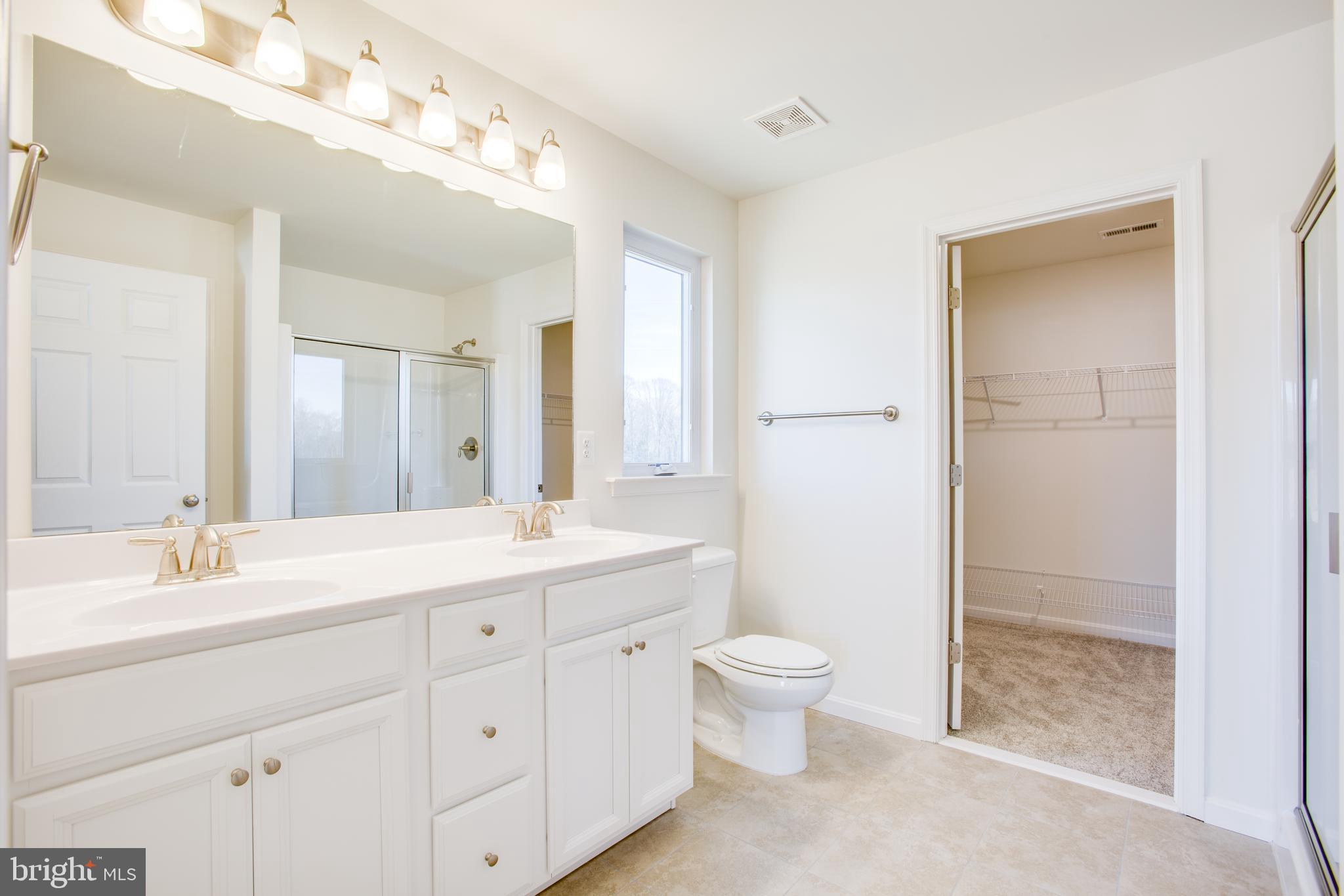 2107 Warrenton Road Fredericksburg, VA 22406 - Photo 29 of 58 a bathroom with a double vanity sink a toilet and a shower