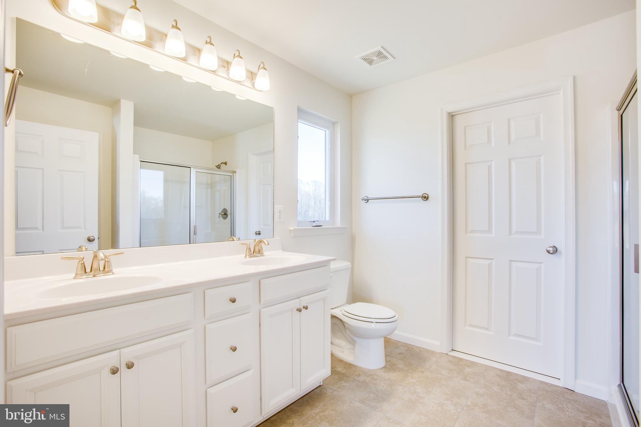 2107 Warrenton Road Fredericksburg, VA 22406 - Photo 30 of 58 a bathroom with a double vanity sink a toilet and a mirror