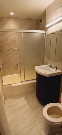 a bathroom with a sink a toilet and shower