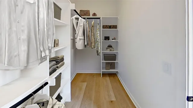 a view of walk in closet with clothes and shoes