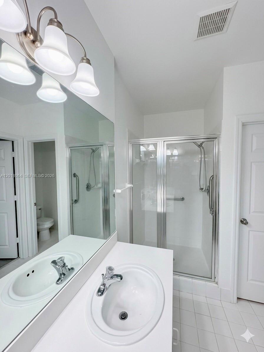 16213 Emerald Cove Road Weston, FL 33331 - Photo 12 of 27 a bathroom with a sink a toilet and shower