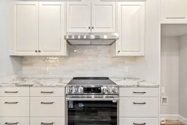 a stove top oven sitting inside of a kitchen