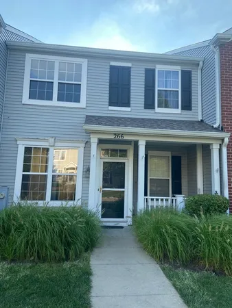 front view of a brick house with a yard