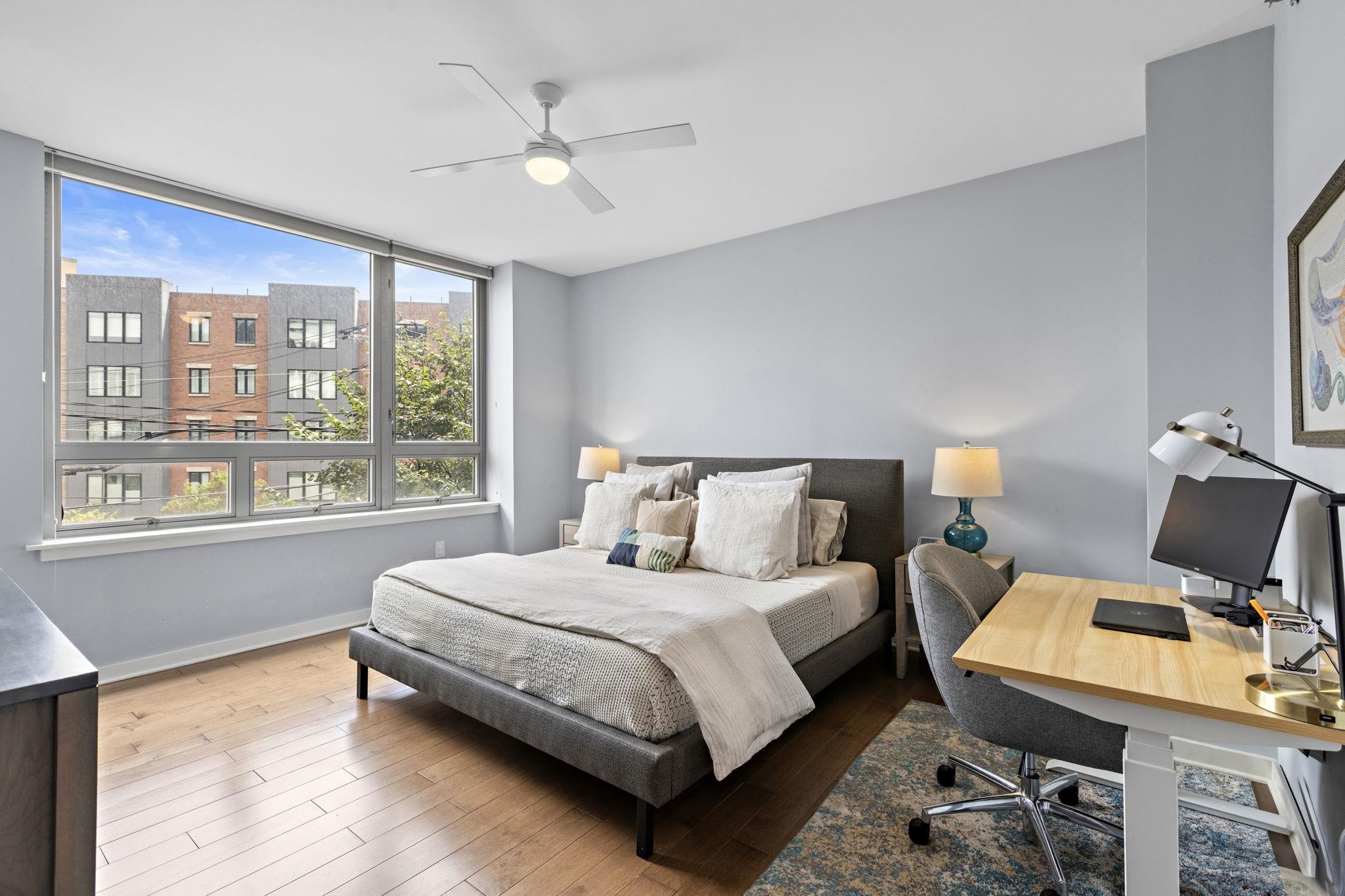 609 Observer Highway, Unit 303 Hoboken, NJ 07030 - Photo 8 of 20 a bedroom with a bed and wooden floor