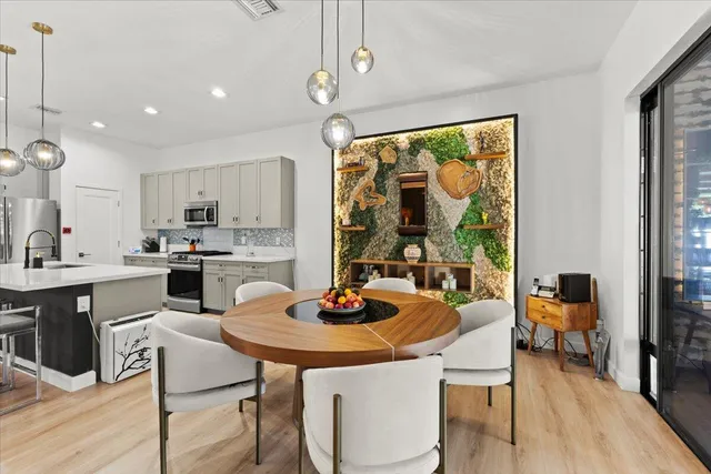 a kitchen with a table chairs sink and cabinets