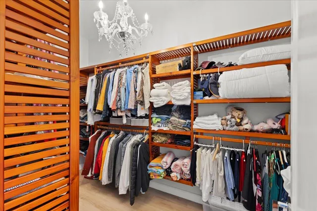 a view of walk in closet with clothes and shoes