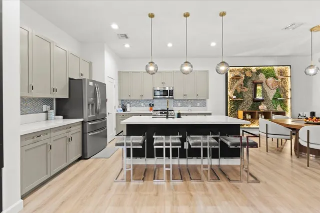 a very nice looking kitchen with a large window wooden floor and stainless steel appliances