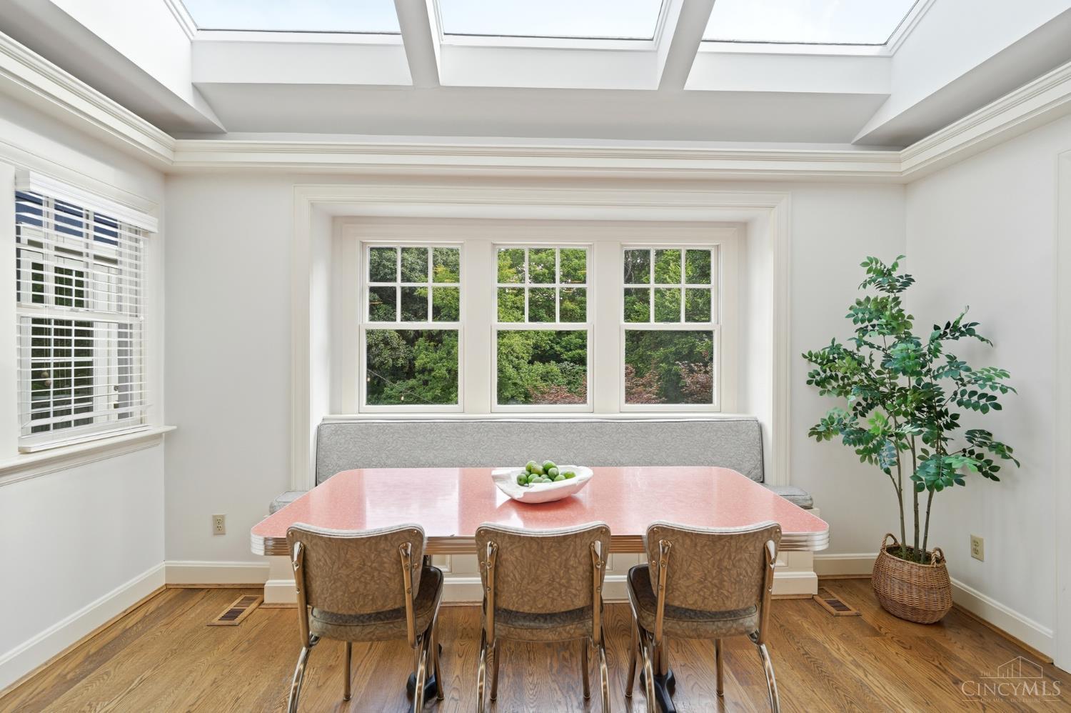 2780 Walsh Road Cincinnati, OH 45208 - Photo 17 of 77 The bright and inviting breakfast room is wrapped in windows and natural light, highlighted by a skylit ceiling and built-in banquette seating. Overlooking lush, tree-lined views, this cheerful space offers the perfect setting for casual dining while maintaining an effortless connection to the kitchen and main living areas.