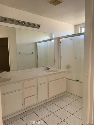 a spacious bathroom with a granite countertop sink mirror and cabinets