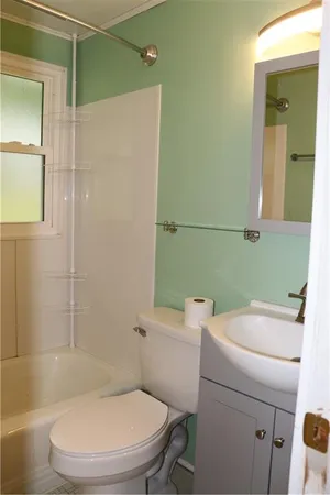 a white toilet sitting next to a bathroom sink and vanity