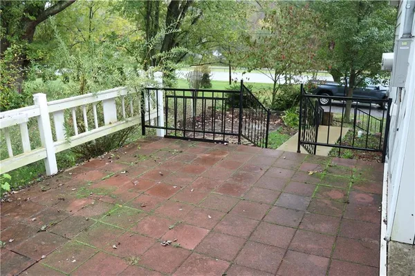 a view of a backyard with large trees and wooden fence
