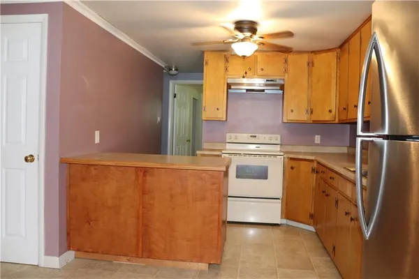 a kitchen with wooden cabinets and white appliances