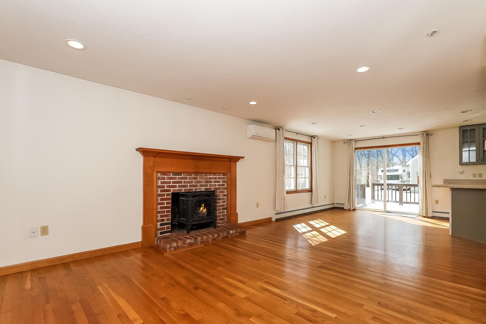 34 Marlboro Road Brewster, MA 02631 - Photo 3 of 23 an empty room with wooden floor fireplace and windows