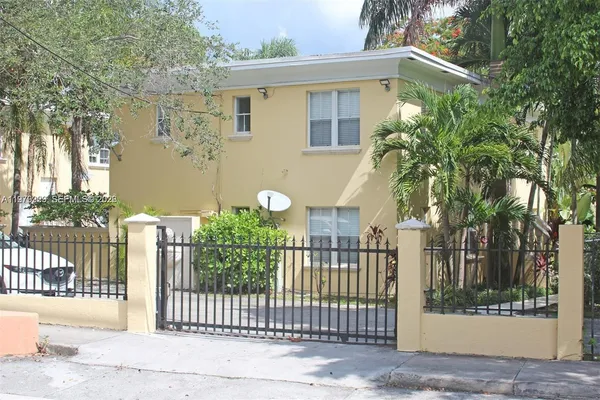 a view of a house with a small yard and wooden fence