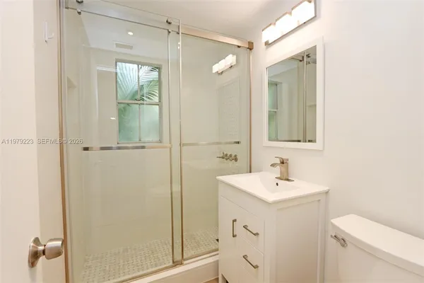 a bathroom with a sink a toilet and shower
