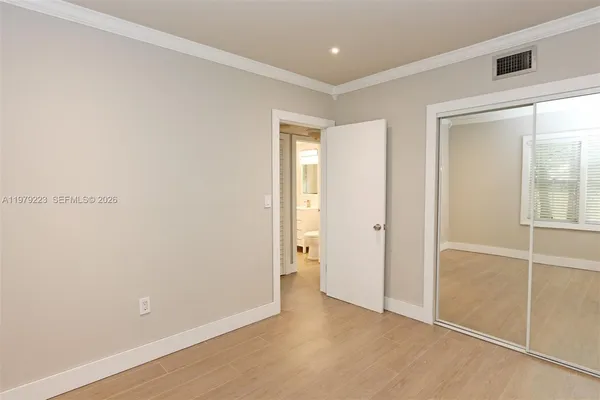 an empty room with closet and mirror