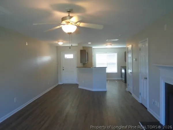 a view of a livingroom and a kitchen with wooden floor