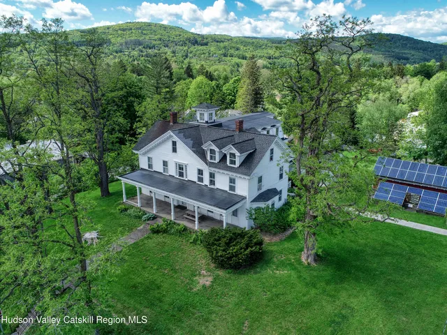 a view of a house with a big yard and large trees