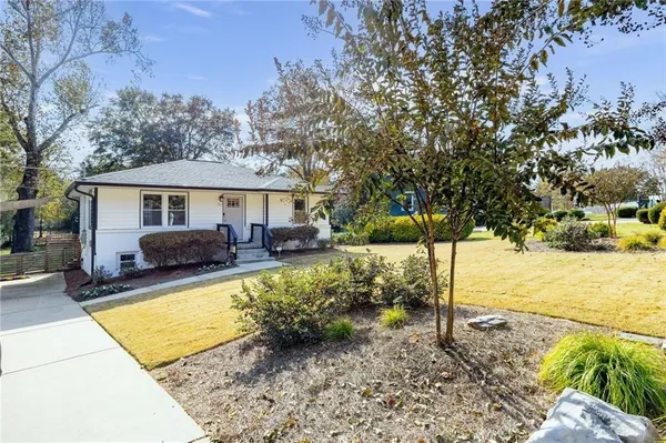 a view of a house with backyard and trees