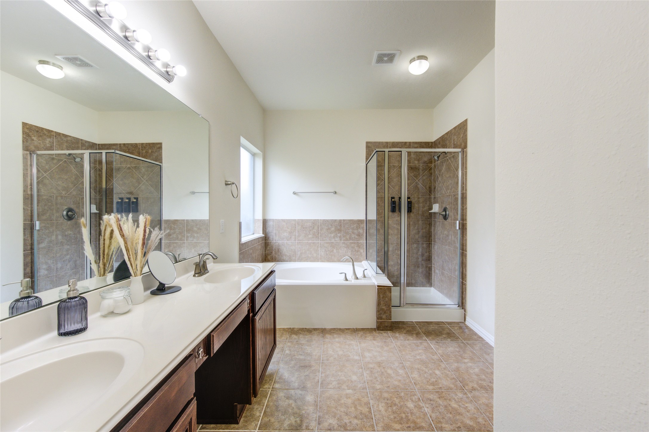 4211 Tristan Ridge Lane Katy, TX 77449 - Photo 18 of 31 a bathroom with a double vanity sink a mirror and a bathtub