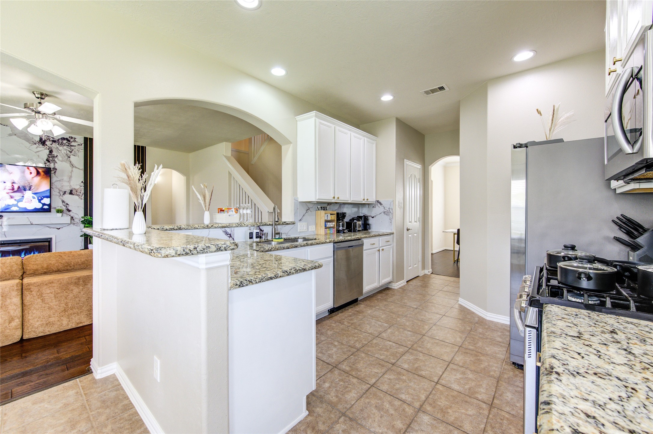 4211 Tristan Ridge Lane Katy, TX 77449 - Photo 9 of 31 a kitchen with kitchen island granite countertop a sink cabinets and stainless steel appliances