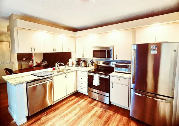 a kitchen with a refrigerator sink and microwave