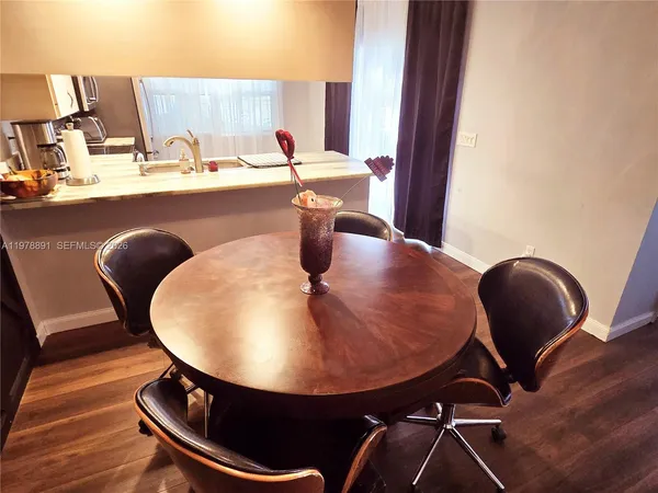 a view of a kitchen with kitchen island a dining table and chairs