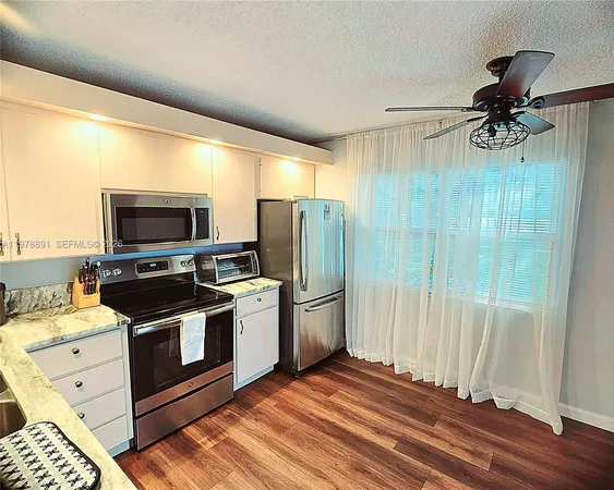 a view of a kitchen with a sink wooden floor and a window