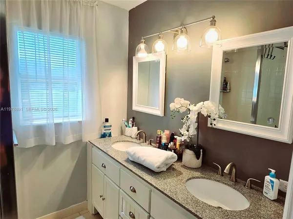 a bathroom with a granite countertop sink and a mirror