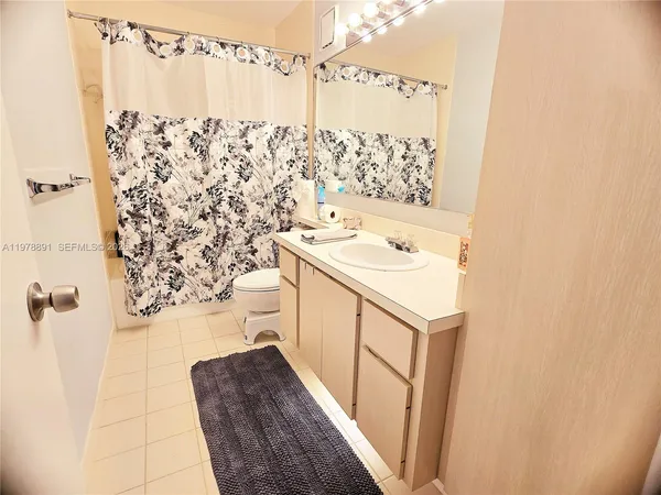 a bathroom with a sink a toilet and shower curtain