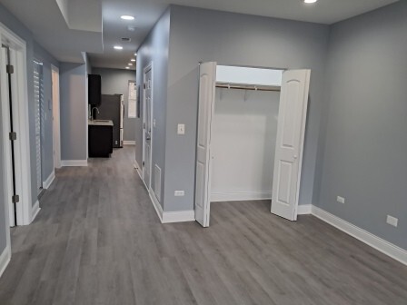 935 West Marquette Road, Unit 9371 Chicago, IL 60621 - Photo 5 of 25 wooden floor in an empty room with a kitchen