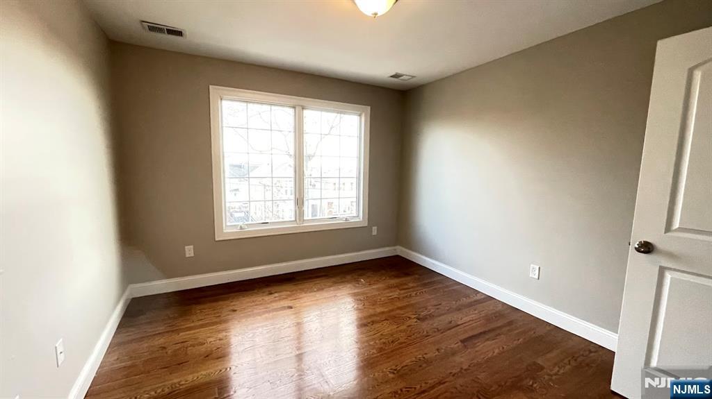 87 Beech Street, Unit 2 Kearny, NJ 07032 - Photo 11 of 13 a view of an empty room with wooden floor and a window