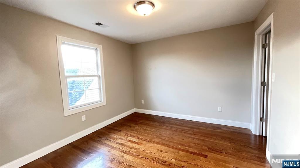 87 Beech Street, Unit 2 Kearny, NJ 07032 - Photo 12 of 13 an empty room with wooden floor and windows