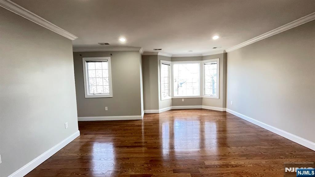 87 Beech Street, Unit 2 Kearny, NJ 07032 - Photo 4 of 13 an empty room with wooden floor and windows