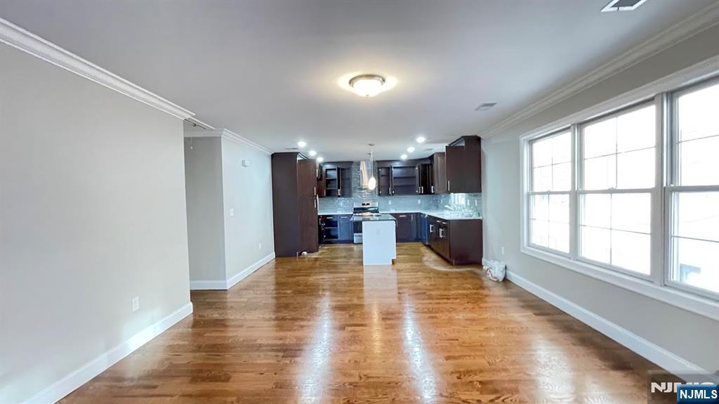 87 Beech Street, Unit 2 Kearny, NJ 07032 - Photo 5 of 13 a large kitchen with kitchen island a large window wooden floor and stainless steel appliances