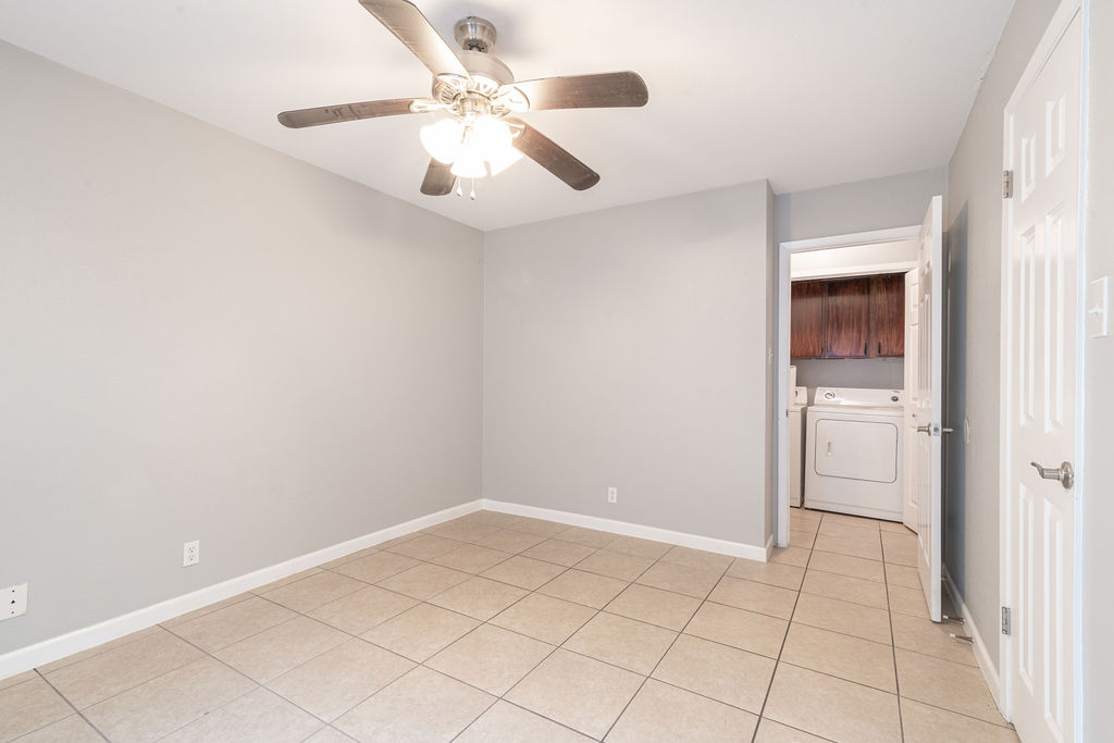 1810 Nicole Circle, Unit B Round Rock, TX 78664 - Photo 21 of 30 an empty room with a ceiling fan and a bathroom