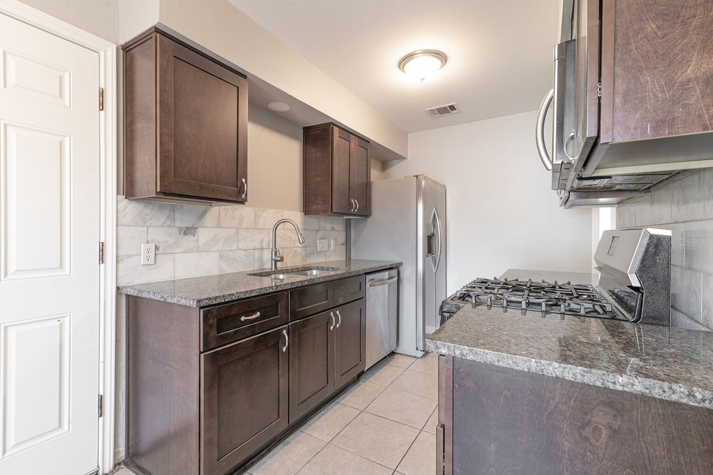 1810 Nicole Circle, Unit B Round Rock, TX 78664 - Photo 3 of 30 a kitchen with granite countertop a sink stove and refrigerator