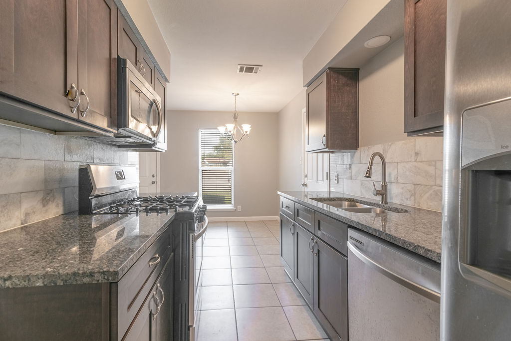 1810 Nicole Circle, Unit B Round Rock, TX 78664 - Photo 4 of 30 a kitchen with stainless steel appliances granite countertop a sink stove and cabinets