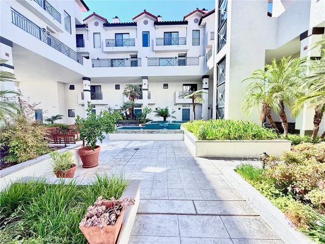 a front view of a multi story residential apartment building with yard