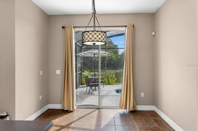 a dining room with wooden floor and a chandelier