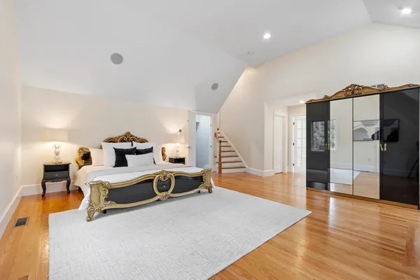a bedroom with a bed table flowerpot and window