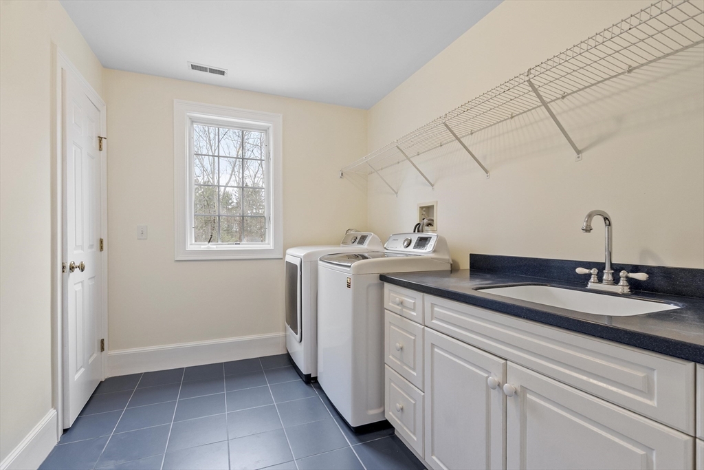 58 Buttrick Lane Carlisle, MA 01741 - Photo 34 of 39 a utility room with cabinets washer and dryer