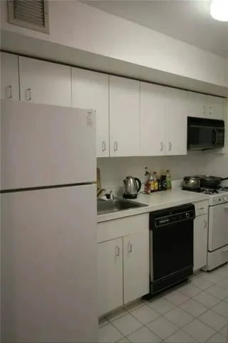 a kitchen with stainless steel appliances granite countertop a refrigerator a stove a sink and a microwave