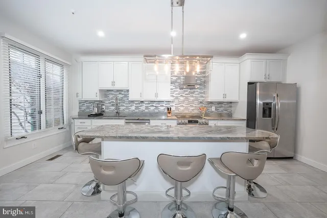 a kitchen with stainless steel appliances granite countertop a sink a stove and a refrigerator