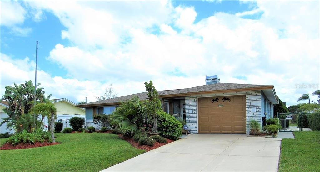 8012 Pineapple Lane Port Richey, FL 34668 - Photo 1 of 1 a front view of a house with a garden
